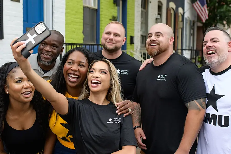 Group of students wearing AMU-branded gear taking a group selfie