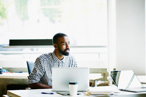 Man sitting at desk in front of laptop